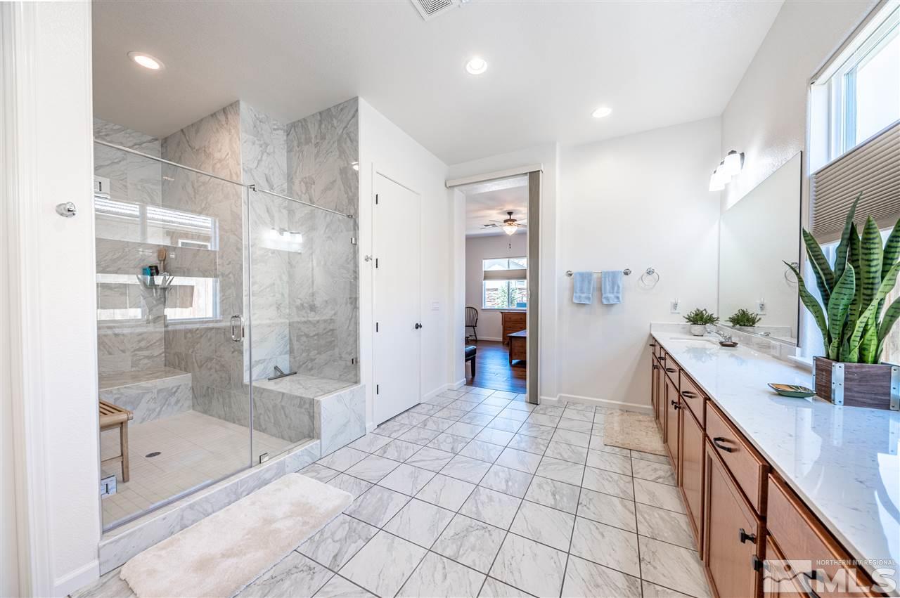 9845 Shadowless Trail Reno, NV 89521 - Photo 20 of 40 a spacious bathroom with a granite countertop shower a sink and a mirror