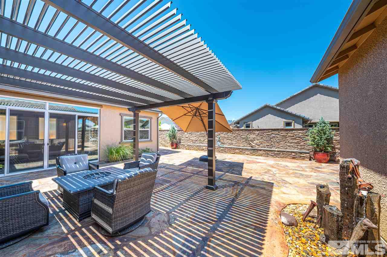 9845 Shadowless Trail Reno, NV 89521 - Photo 24 of 40 a view of a patio with dining table and chairs under an umbrella with a barbeque