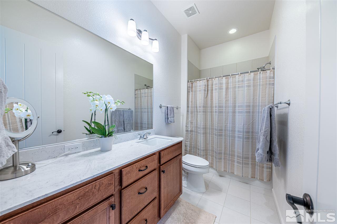 9845 Shadowless Trail Reno, NV 89521 - Photo 28 of 40 a bathroom with a granite countertop sink a toilet and shower