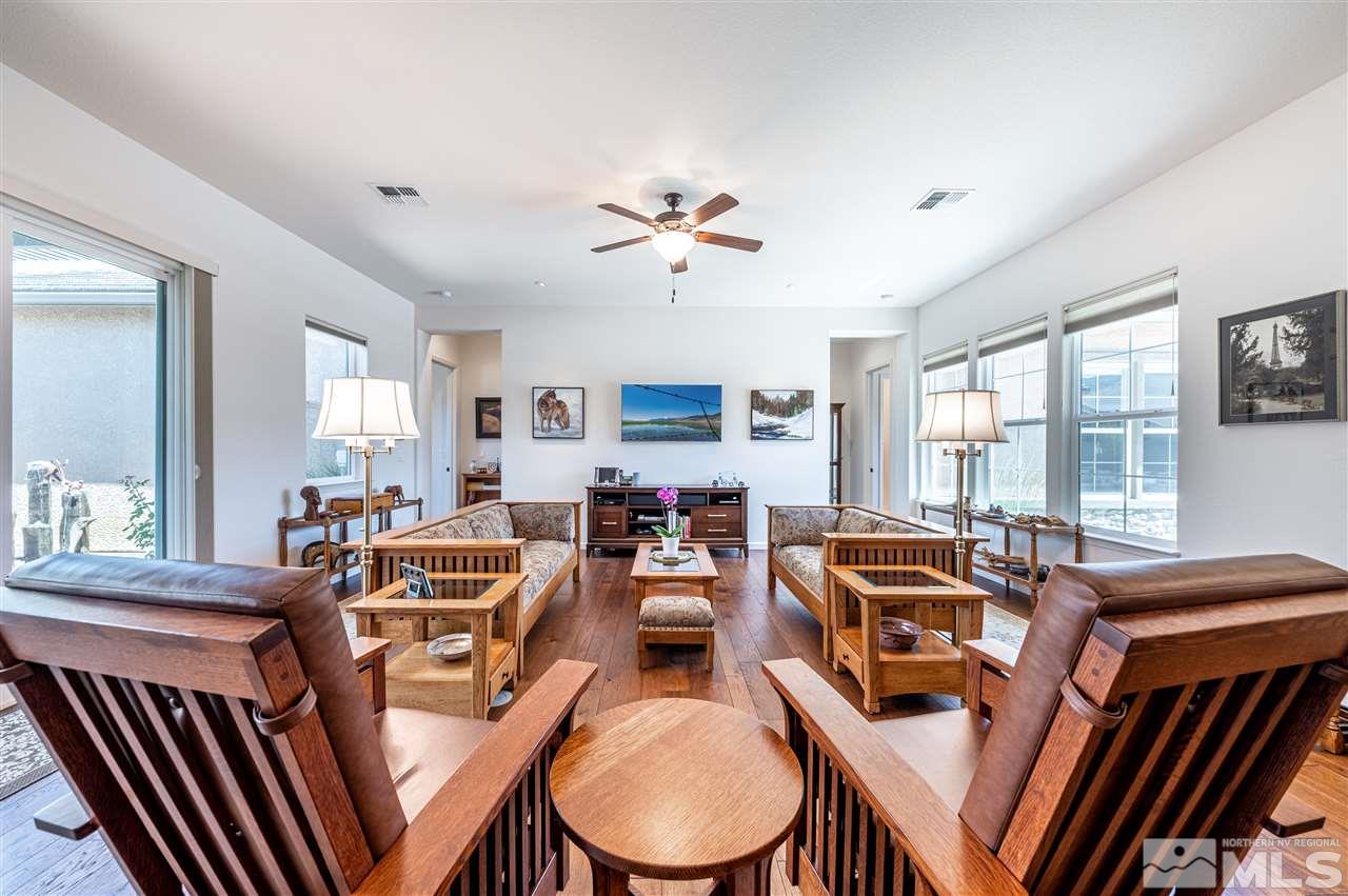9845 Shadowless Trail Reno, NV 89521 - Photo 10 of 40 a dining room with furniture a chandelier a large window and wooden floor