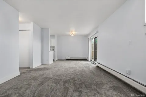 a view of an empty room with a fireplace and a window