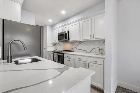 a kitchen with a sink appliances and cabinets