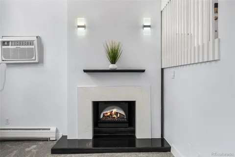 a view of a livingroom with wooden floor and a fireplace