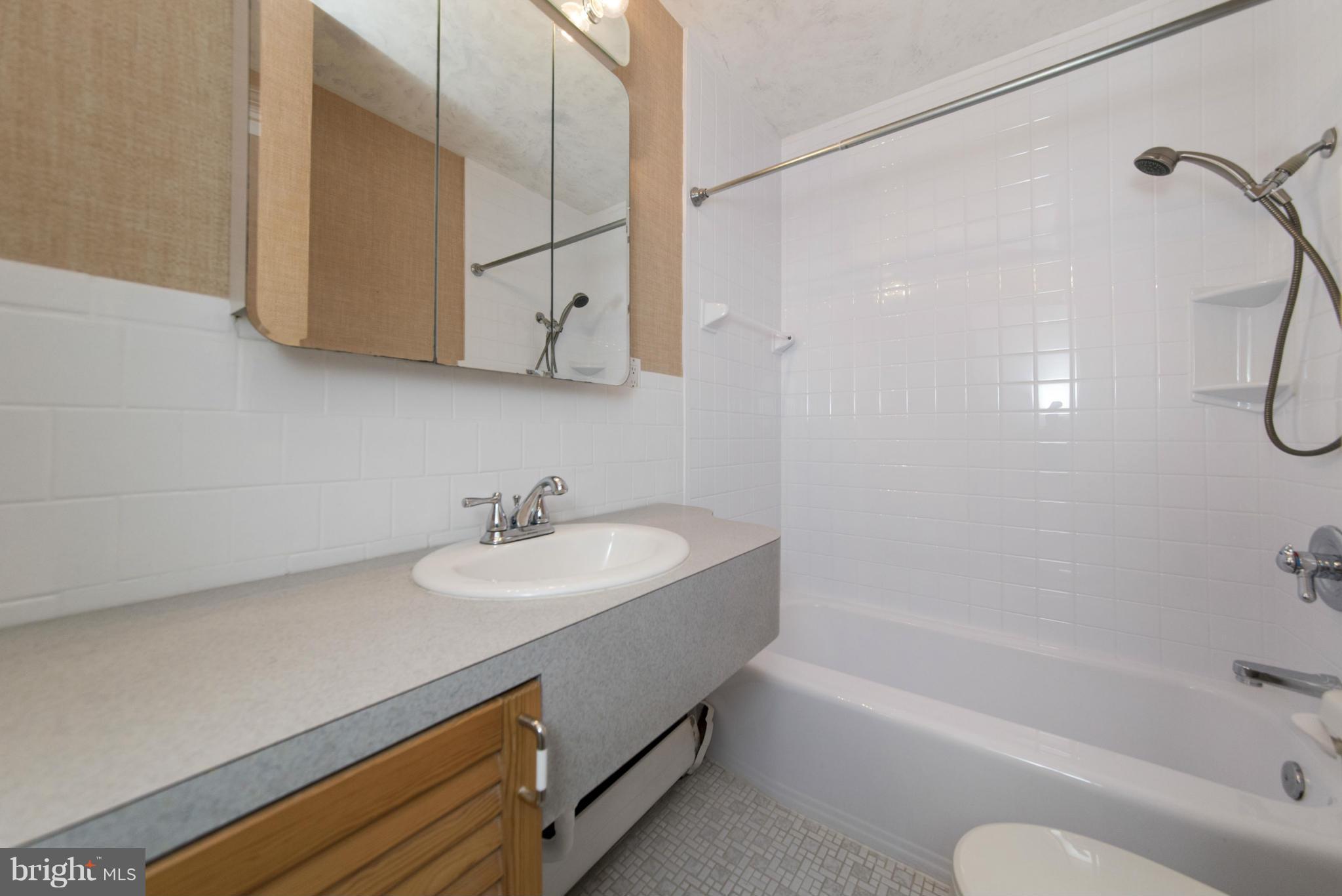 1107 Litchfield Road Baltimore, MD 21239 - Photo 16 of 30 a bathroom with a sink a toilet and bathtub