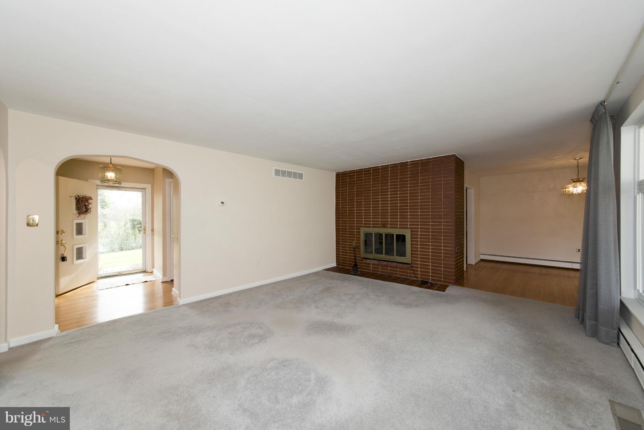 1107 Litchfield Road Baltimore, MD 21239 - Photo 4 of 30 an empty room with a fireplace and cabinet