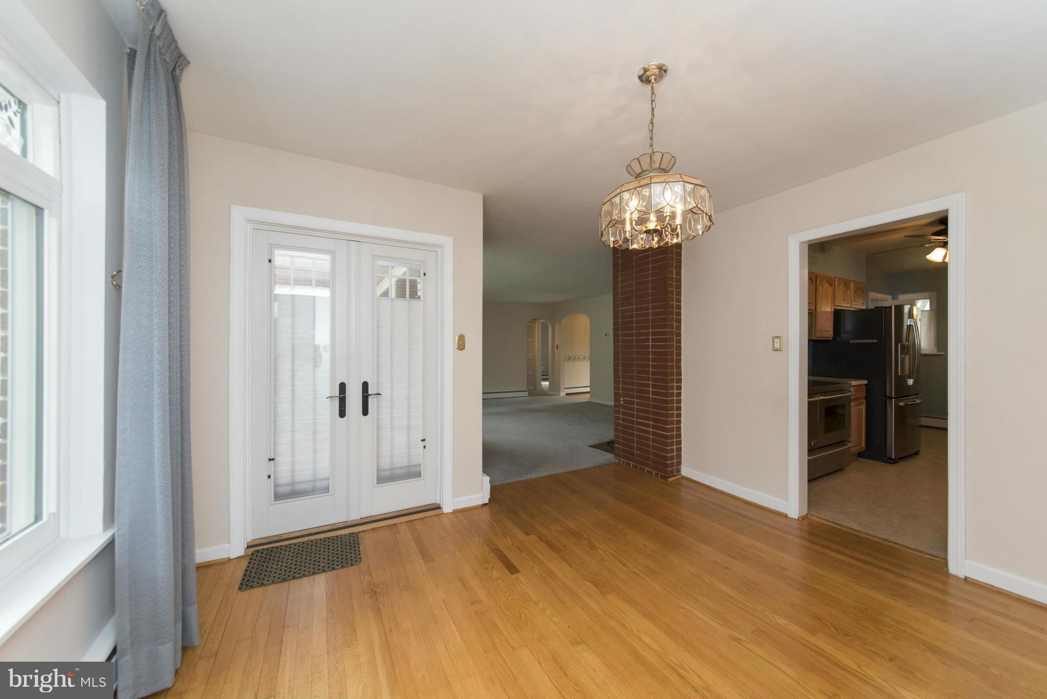 1107 Litchfield Road Baltimore, MD 21239 - Photo 7 of 30 a view of a hallway with wooden floor and a chandelier