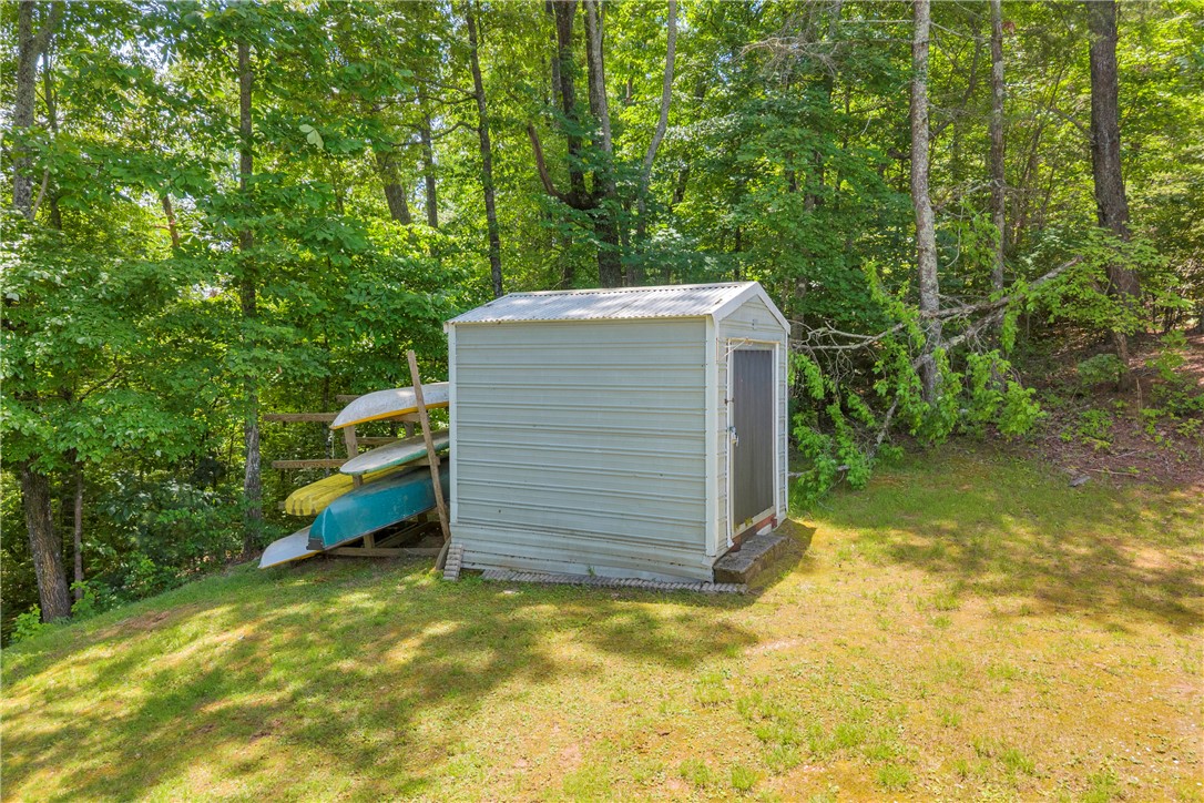 334 Lake Becky Road Mountain Rest, SC 29664 - Photo 25 of 46 A well-maintained storage shed offers ample space for outdoor equipment, nestled against a backdrop of mature trees.