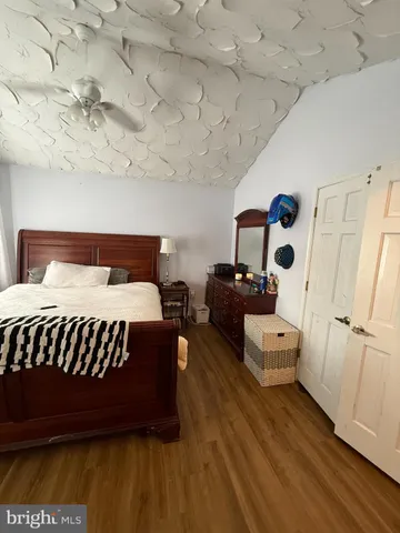 a bed sitting in a spacious bedroom next to a larger window