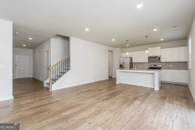 a view of kitchen with microwave a stove and a sink