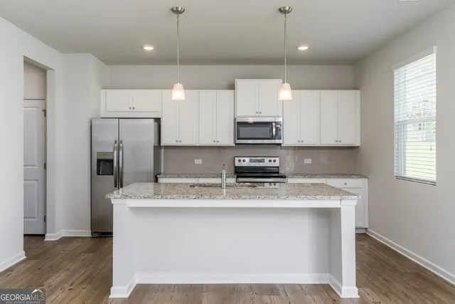 a kitchen with stainless steel appliances granite countertop a refrigerator stove and microwave