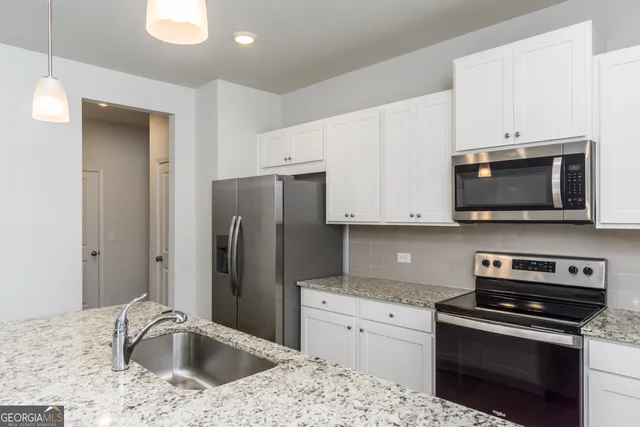 a kitchen with stainless steel appliances granite countertop a sink and a stove
