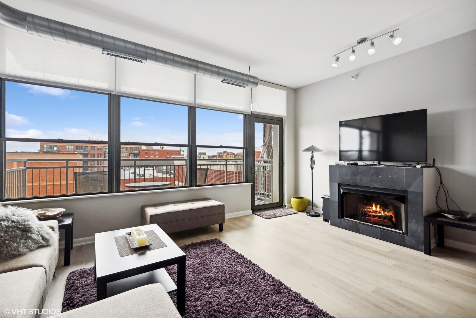 1200 West Monroe Street, Unit 619 Chicago, IL 60607 - Photo 4 of 16 a living room with furniture a flat screen tv and a fireplace