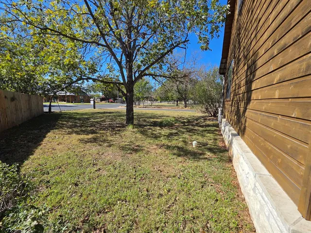 a backyard of a house with large trees