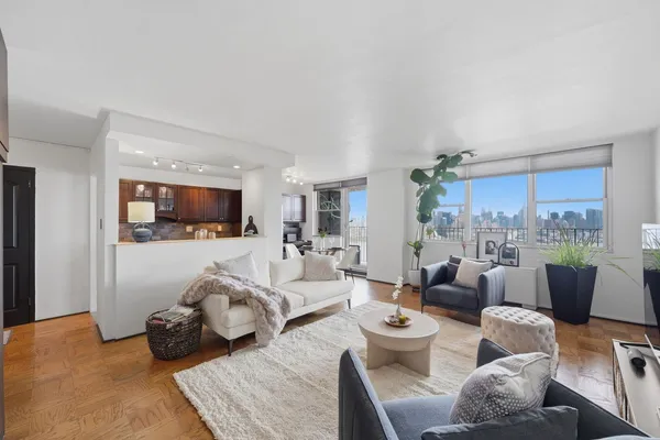 a living room with furniture and view of kitchen