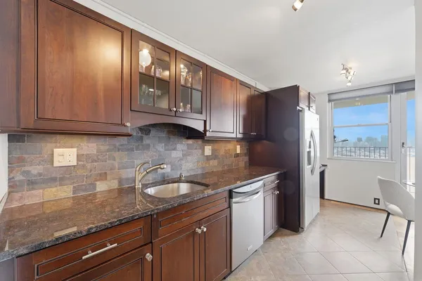 a kitchen with stainless steel appliances granite countertop a sink stove and cabinets