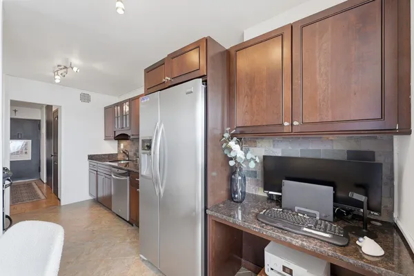 a kitchen with a refrigerator and a stove top oven