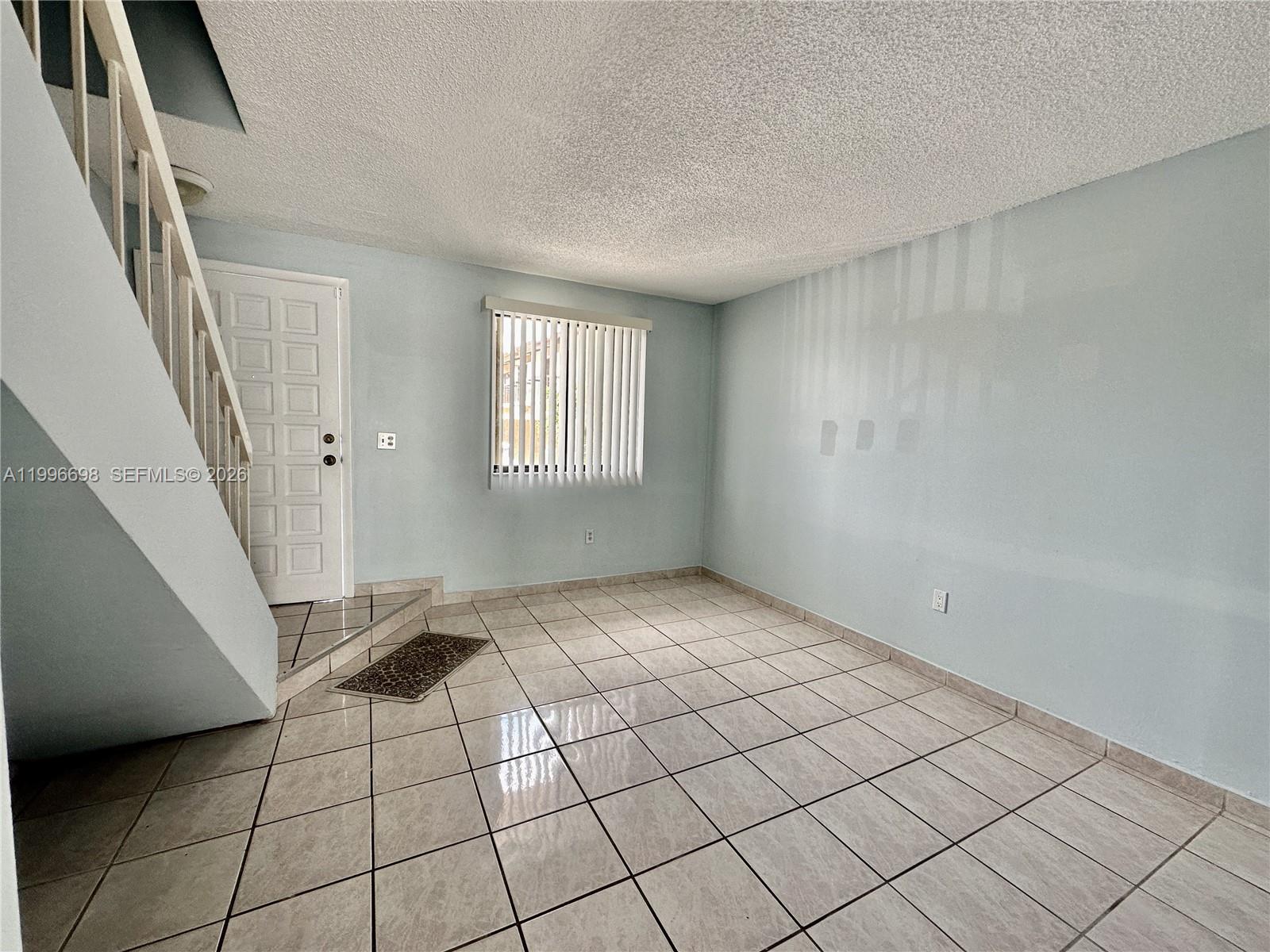 1911 Southwest 107th Avenue, Unit 1006 Miami, FL 33165 - Photo 4 of 17 a view of an empty room and window