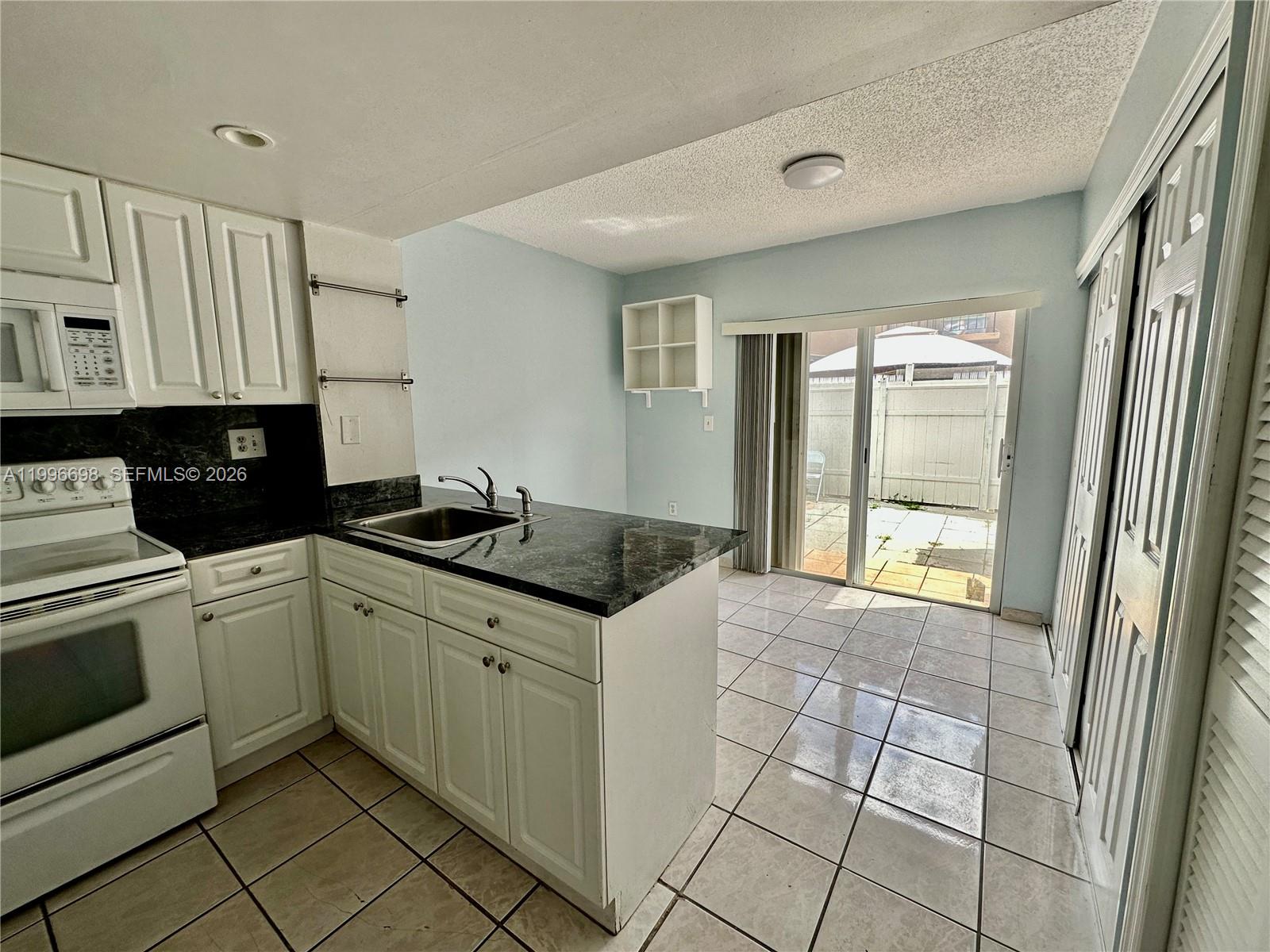 1911 Southwest 107th Avenue, Unit 1006 Miami, FL 33165 - Photo 6 of 17 a kitchen with stainless steel appliances granite countertop a sink and cabinets