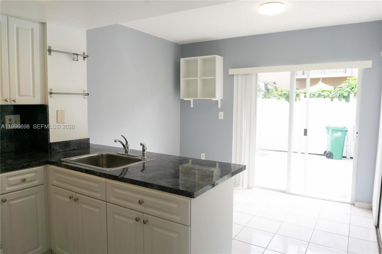 1911 Southwest 107th Avenue, Unit 1006 Miami, FL 33165 - Photo 8 of 17 a kitchen with granite countertop a sink and a refrigerator