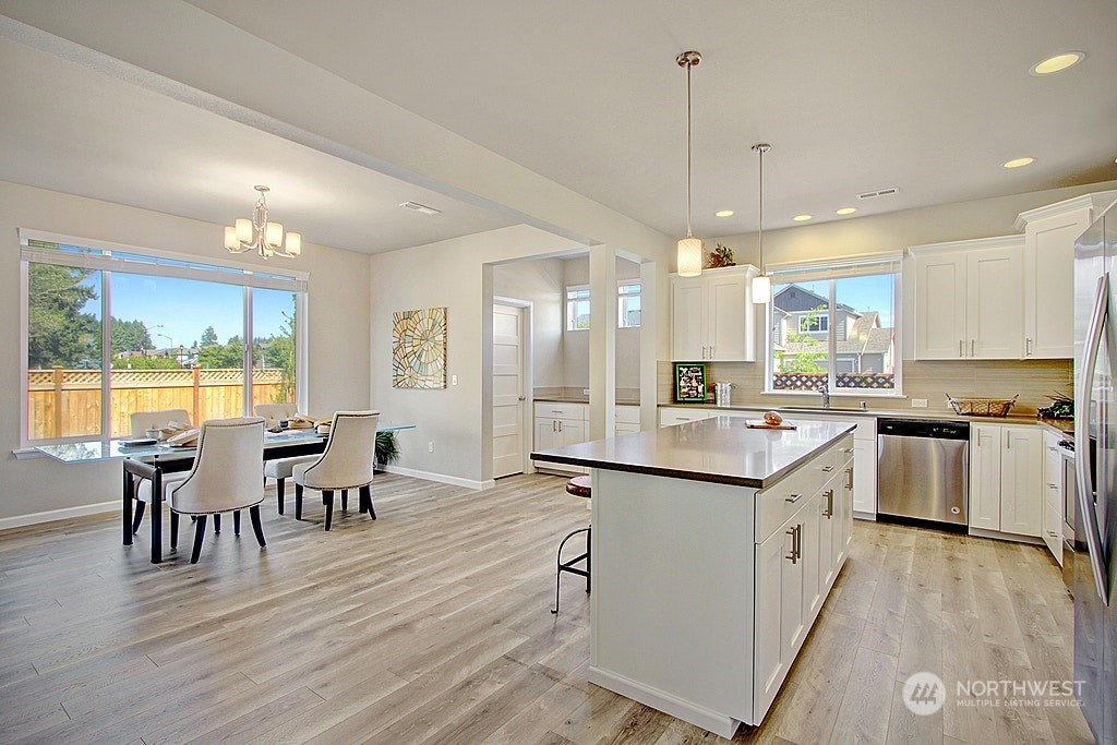 3008 Stephanie Loop Northeast Lacey, WA 98516 - Photo 2 of 5 a large kitchen with kitchen island a island a sink a stove and wooden floor