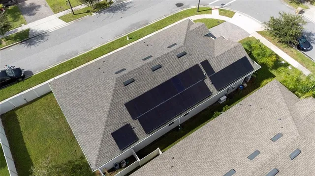 a living room with stainless steel appliances furniture a rug and a kitchen view