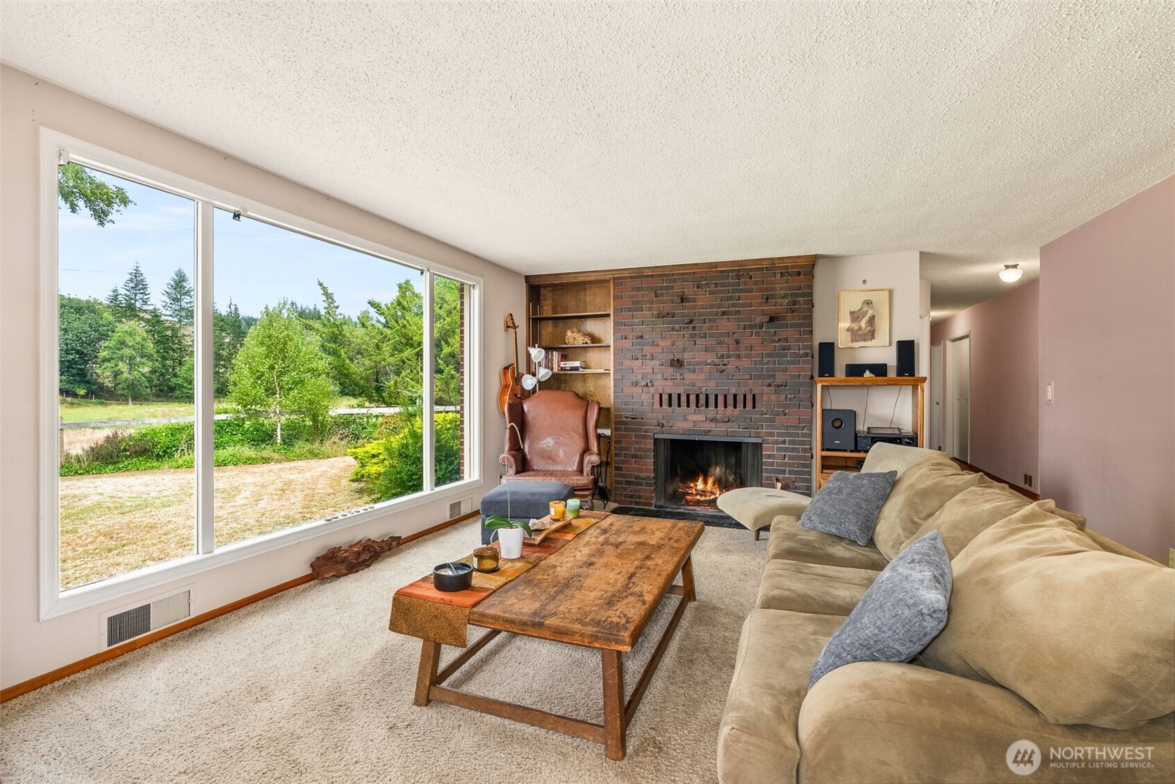 627 Wynoochee Valley Road Montesano, WA 98563 - Photo 24 of 40 a living room with furniture a large window and a fireplace