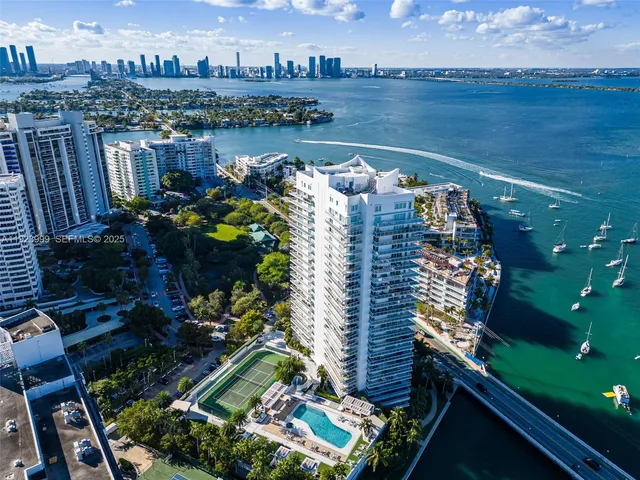 a view of a tennis ground with large trees