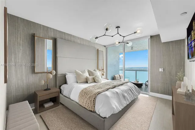 a bedroom with a bed chandelier and a window