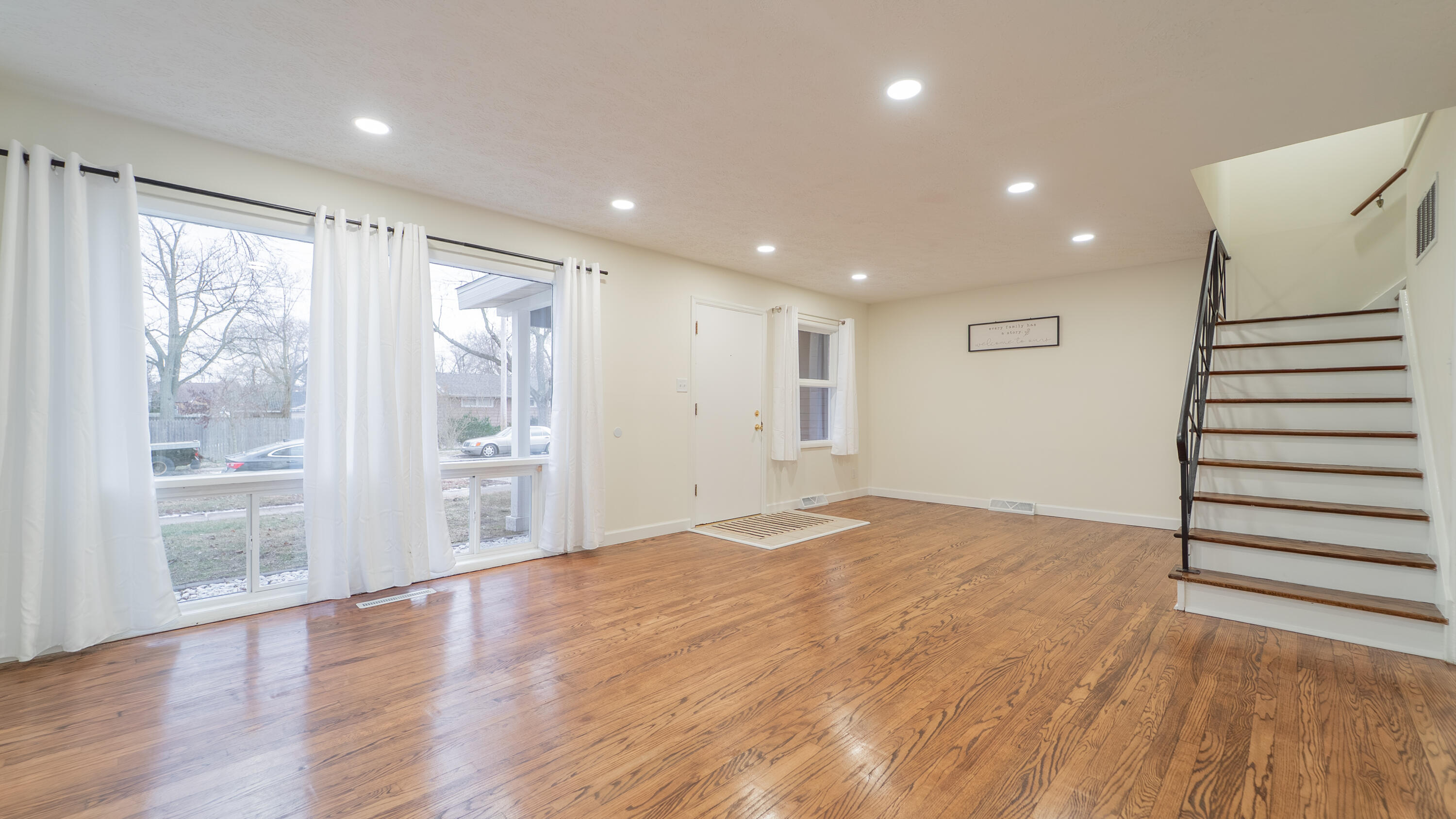 722 Madison Street Michigan City, IN 46360 - Photo 14 of 43 a view of an empty room with wooden floor and a window