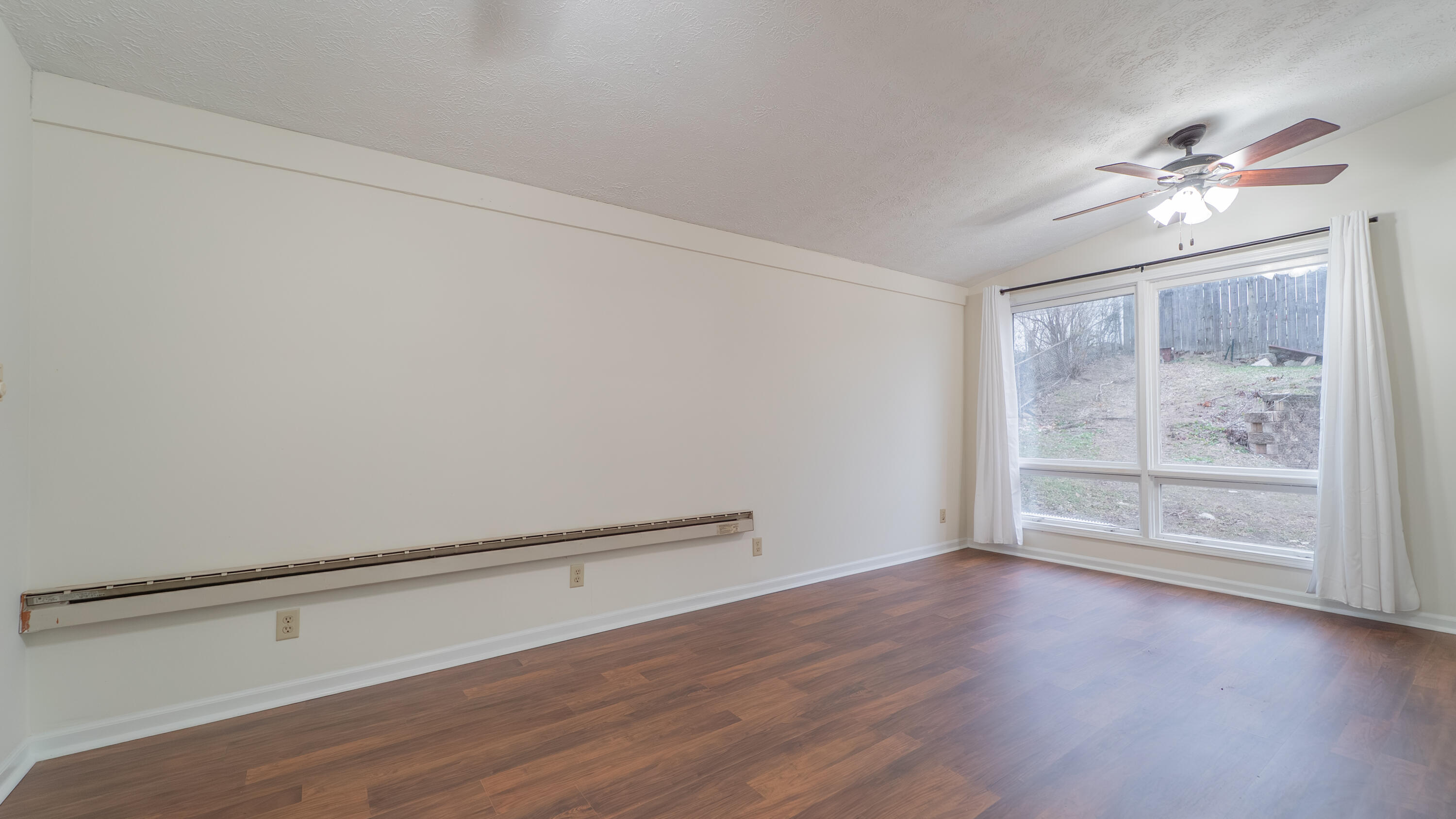 722 Madison Street Michigan City, IN 46360 - Photo 20 of 43 a view of an empty room with a window and wooden floor