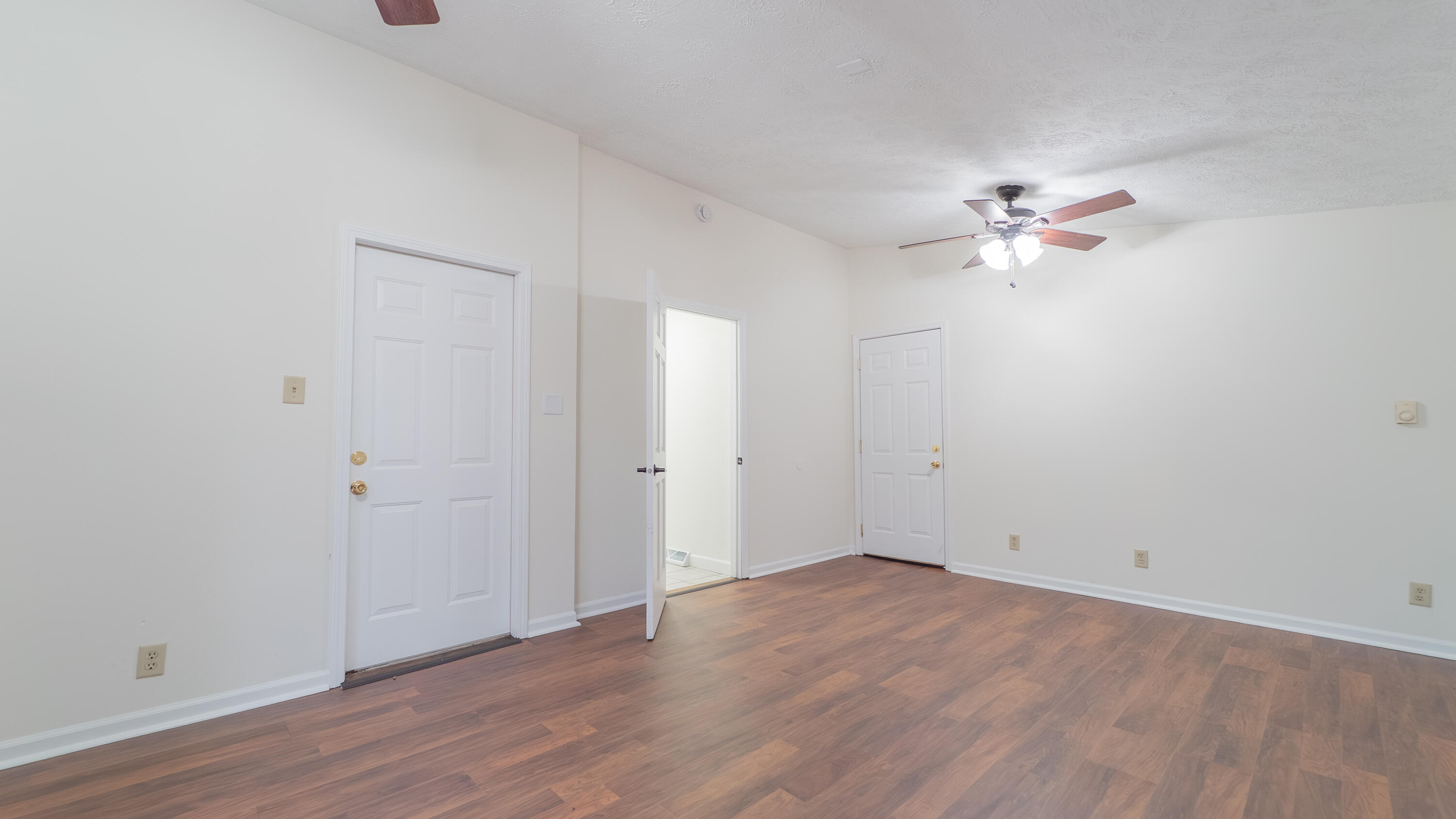 722 Madison Street Michigan City, IN 46360 - Photo 21 of 43 an empty room with wooden floor and ceiling fan