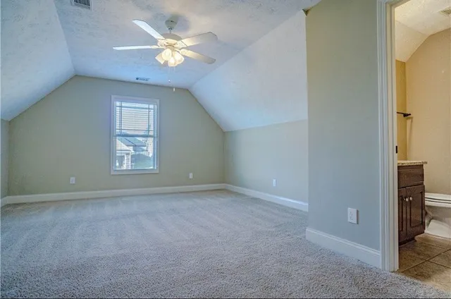 an empty room with closet and a ceiling fan