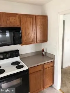 a kitchen with granite countertop a sink a stove and cabinets