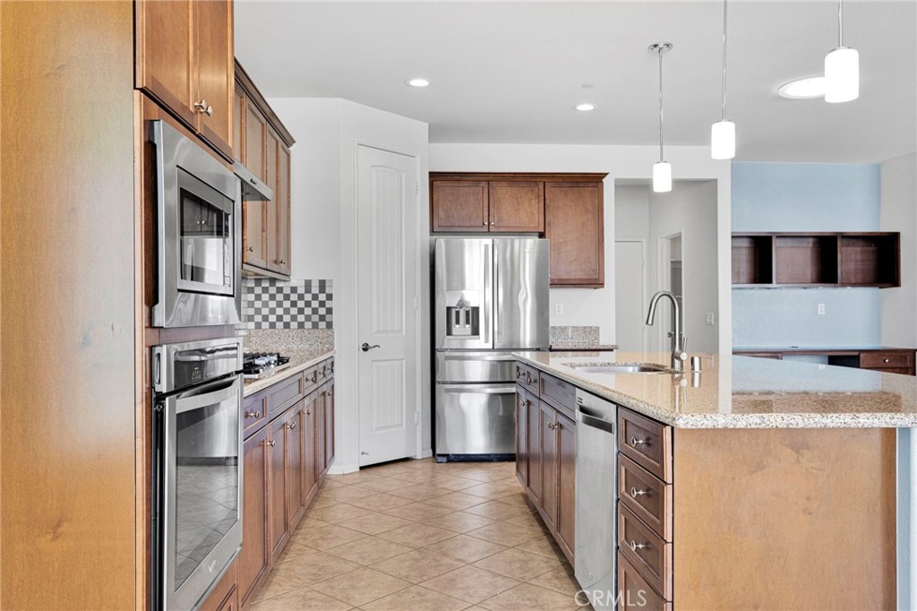 18968 Raven Street Apple Valley, CA 92308 - Photo 19 of 53 a kitchen with stainless steel appliances granite countertop a sink stove and refrigerator