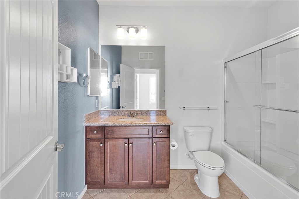 18968 Raven Street Apple Valley, CA 92308 - Photo 35 of 53 a bathroom with a granite countertop toilet a sink and a mirror