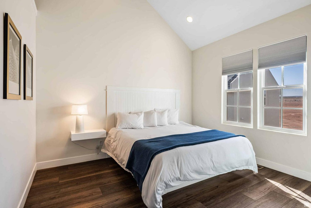 4311 Canterbury Road, Unit F2 Hurricane, UT 84737 - Photo 18 of 18 Vaulted ceiling room featuring wood-finish flooring, two large windows with cellular shades, and a built-in floating nightstand