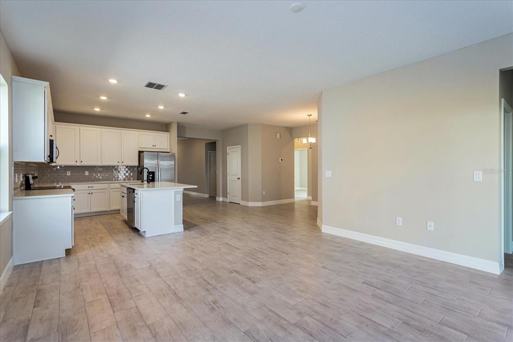 2031 Firethorn Loop Haines City, FL 33844 - Photo 10 of 20 a view of kitchen with granite countertop a sink and white cabinets with wooden floor