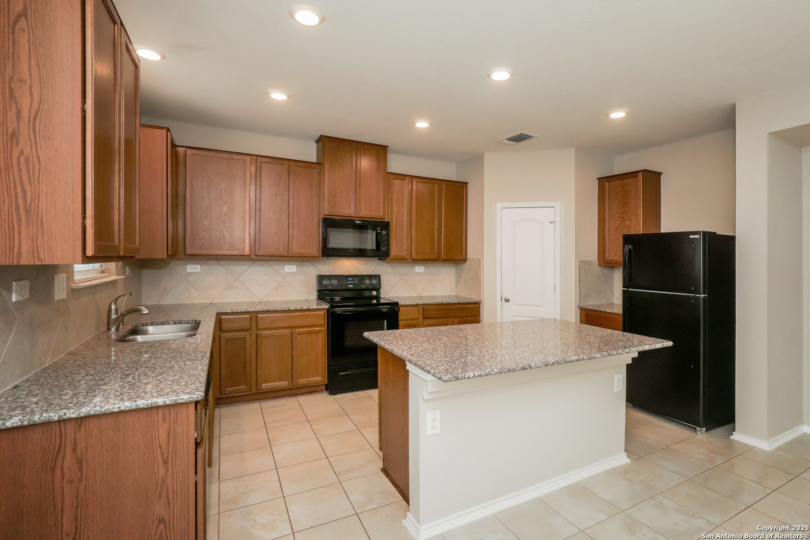 540 Landmark Gate Cibolo, TX 78108 - Photo 6 of 22 a kitchen with kitchen island granite countertop stainless steel appliances a stove refrigerator sink and microwave