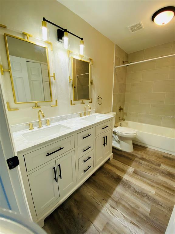 148 Douglas Road West, Unit C Oldsmar, FL 34677 - Photo 24 of 25 a bathroom with a double vanity sink a toilet and a bathtub