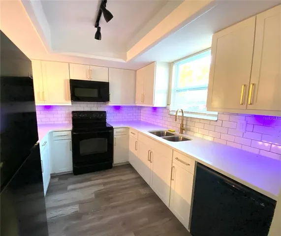 a kitchen with a sink dishwasher a stove and a refrigerator