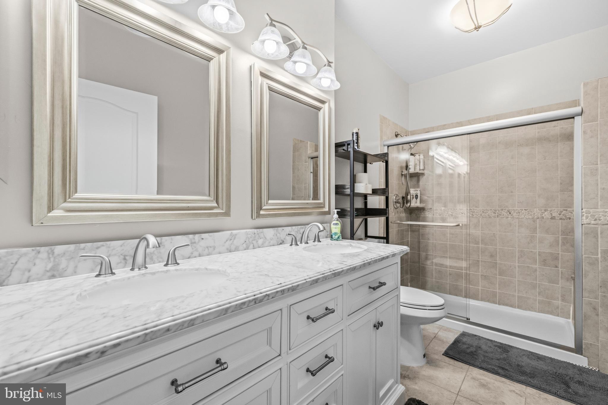 7706 Haynes Point Way, Unit D Alexandria, VA 22315 - Photo 17 of 27 a bathroom with a granite countertop sink a toilet a mirror and shower