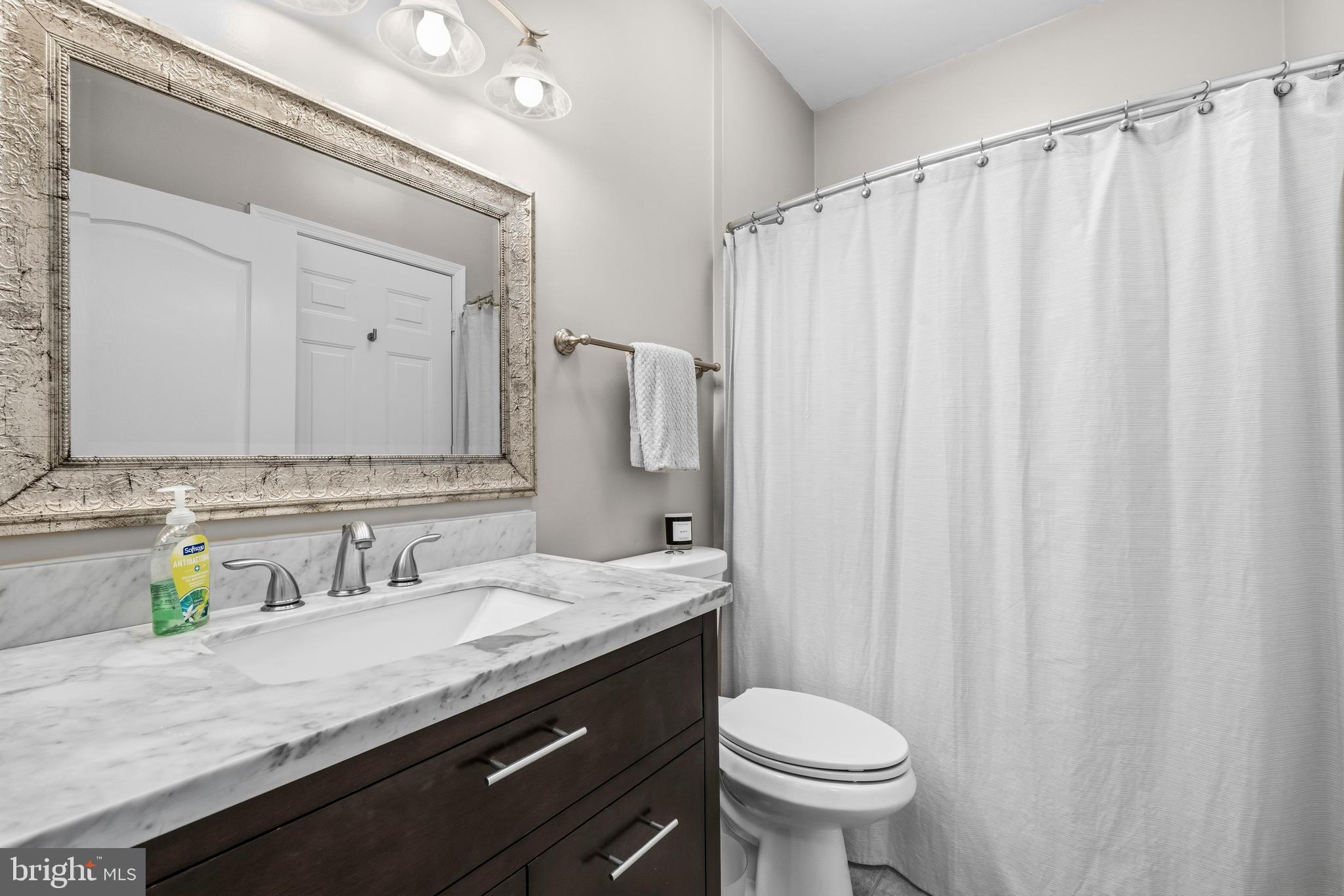 7706 Haynes Point Way, Unit D Alexandria, VA 22315 - Photo 20 of 27 a bathroom with a granite countertop sink toilet and a mirror
