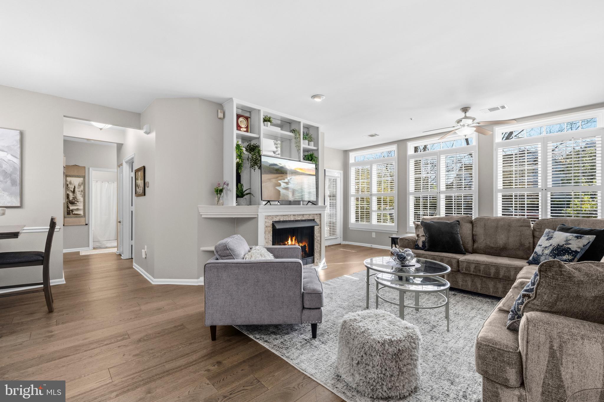 7706 Haynes Point Way, Unit D Alexandria, VA 22315 - Photo 26 of 27 a living room with furniture a fireplace and a large window with garden view