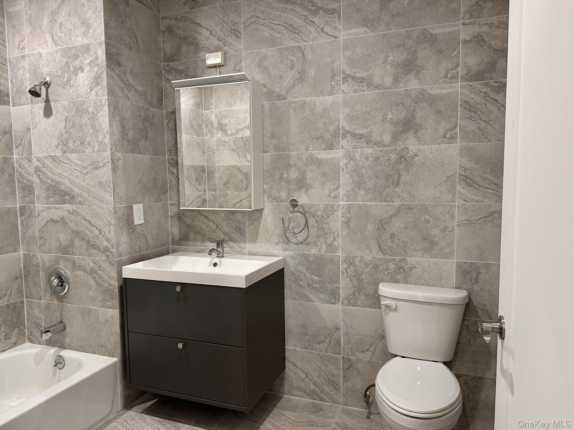 362 West Merrick Road, Unit 107 Valley Stream, NY 11580 - Photo 2 of 7 Full bath featuring tile walls, vanity, and shower / washtub combination