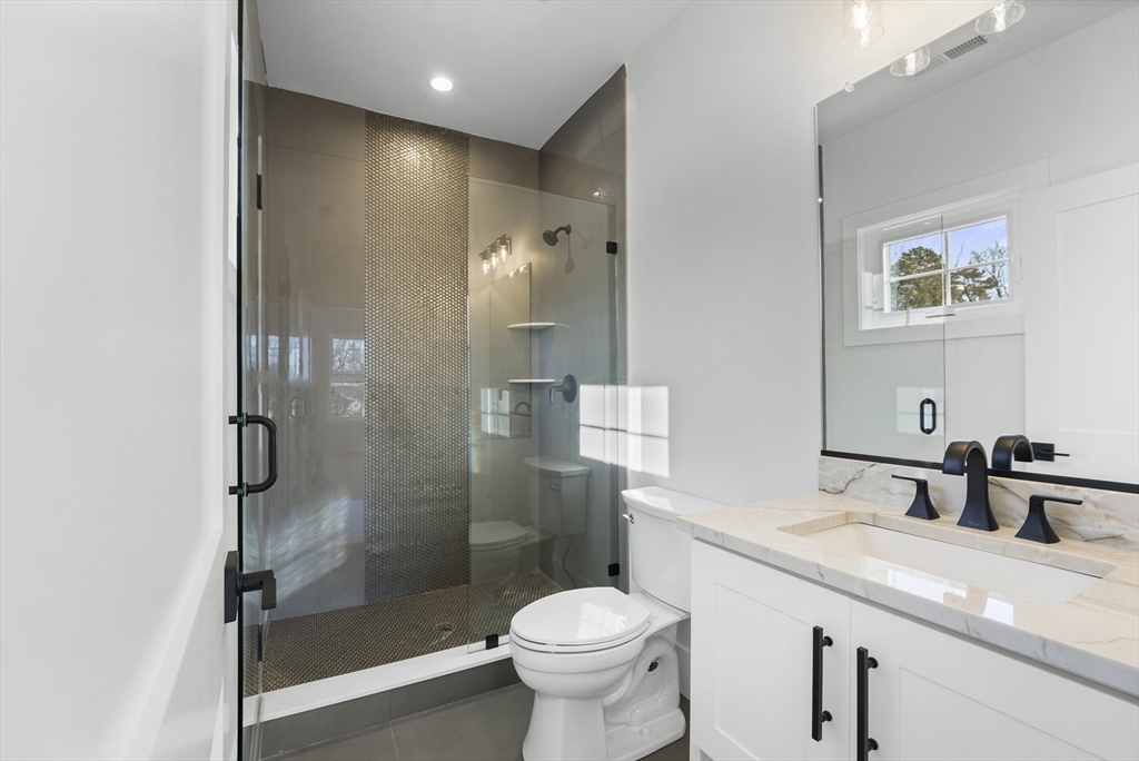 345 Central Avenue Needham, MA 02494 - Photo 23 of 33 a bathroom with a granite countertop toilet sink and shower