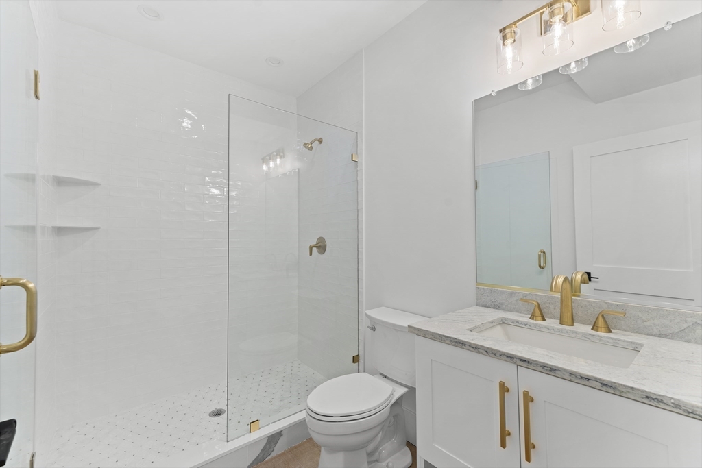345 Central Avenue Needham, MA 02494 - Photo 30 of 33 a bathroom with a granite countertop sink a toilet and shower