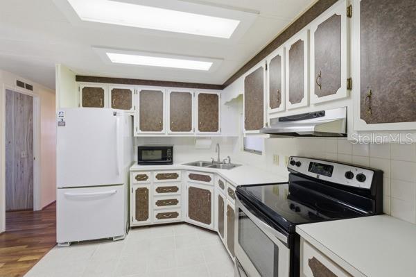 101 Mango Cove Leesburg, FL 34748 - Photo 18 of 28 a kitchen with stainless steel appliances granite countertop a stove and a refrigerator