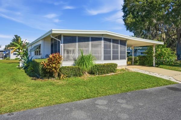 101 Mango Cove Leesburg, FL 34748 - Photo 24 of 28 a front view of a house with a yard and potted plants