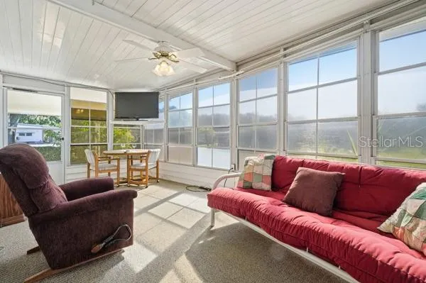 a living room with furniture and a floor to ceiling window