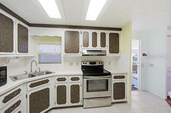 101 Mango Cove Leesburg, FL 34748 - Photo 7 of 28 a kitchen with stainless steel appliances a stove a sink and a microwave
